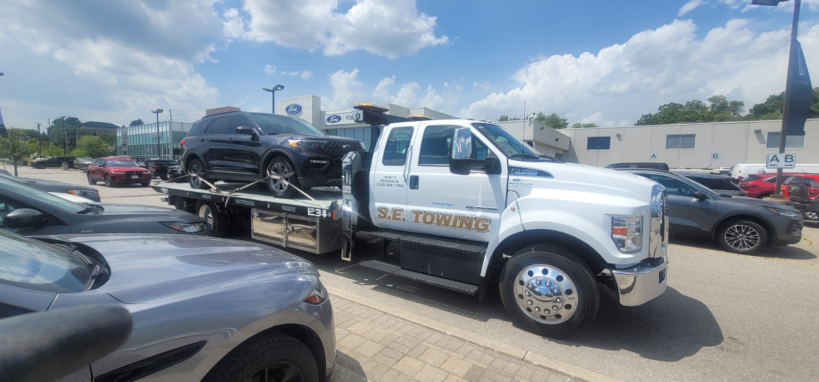 S.E. Towing F-750 flatbed loading a black Range Rover Velar in Oshawa