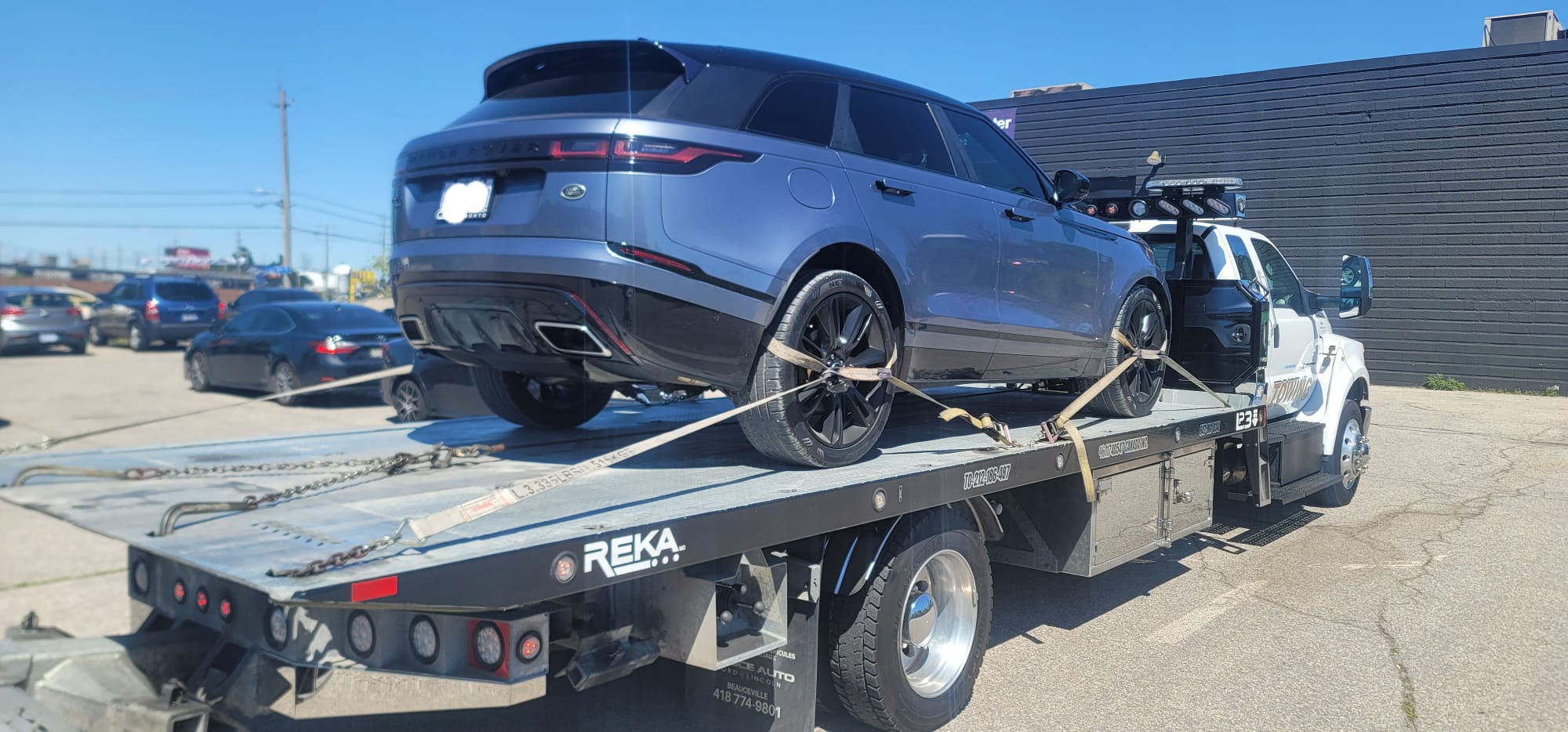S.E. Towing flatbed carrying a grey Range Rover Velar luxury SUV in Whitby