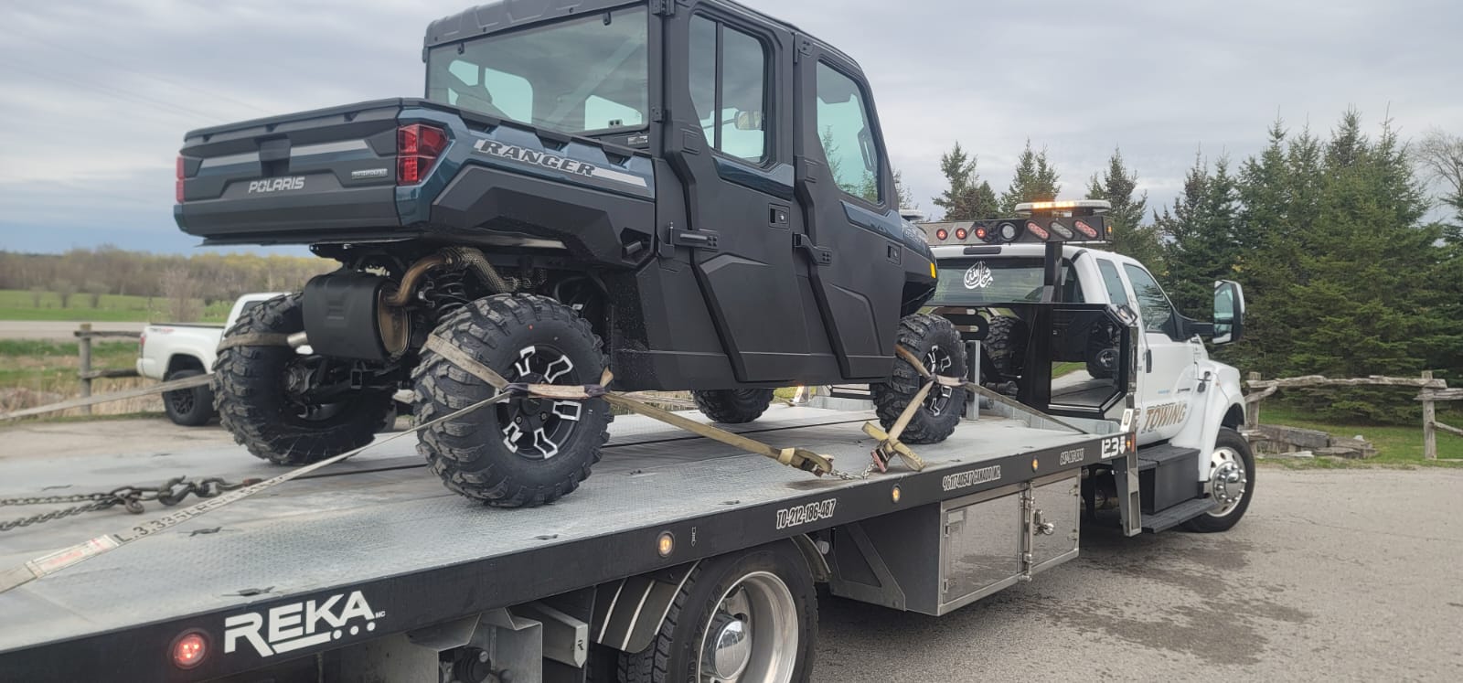 Polaris Ranger side-by-side UTV secured on S.E. Towing flatbed in rural Ontario