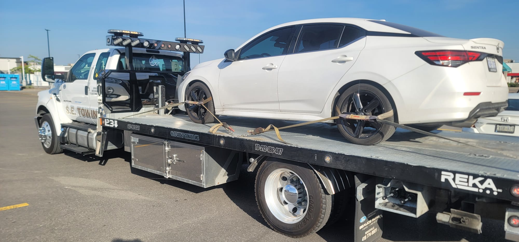 White Nissan Sentra loaded on S.E. Towing flatbed in Ajax