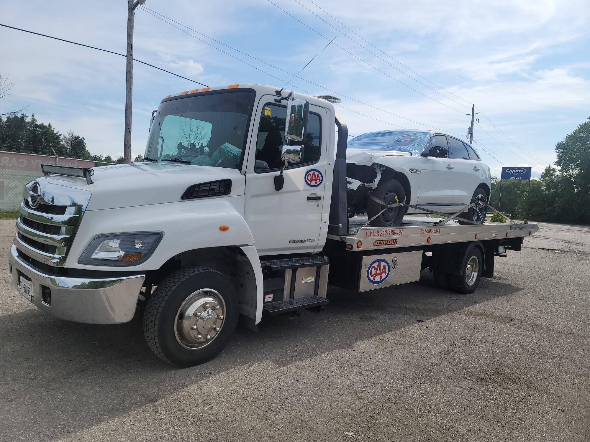 Hino flatbed loaded with a Jaguar SUV