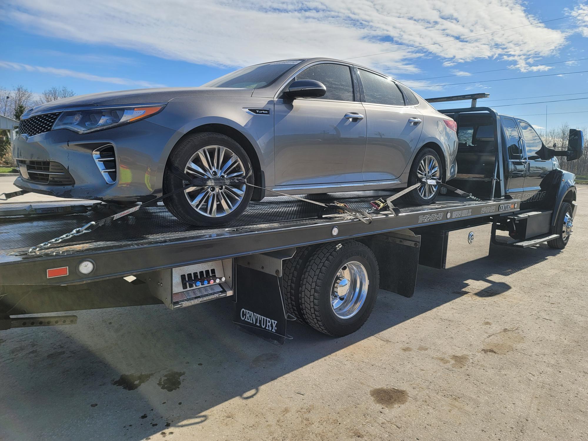 Silver Kia Optima safely strapped on Century flatbed
